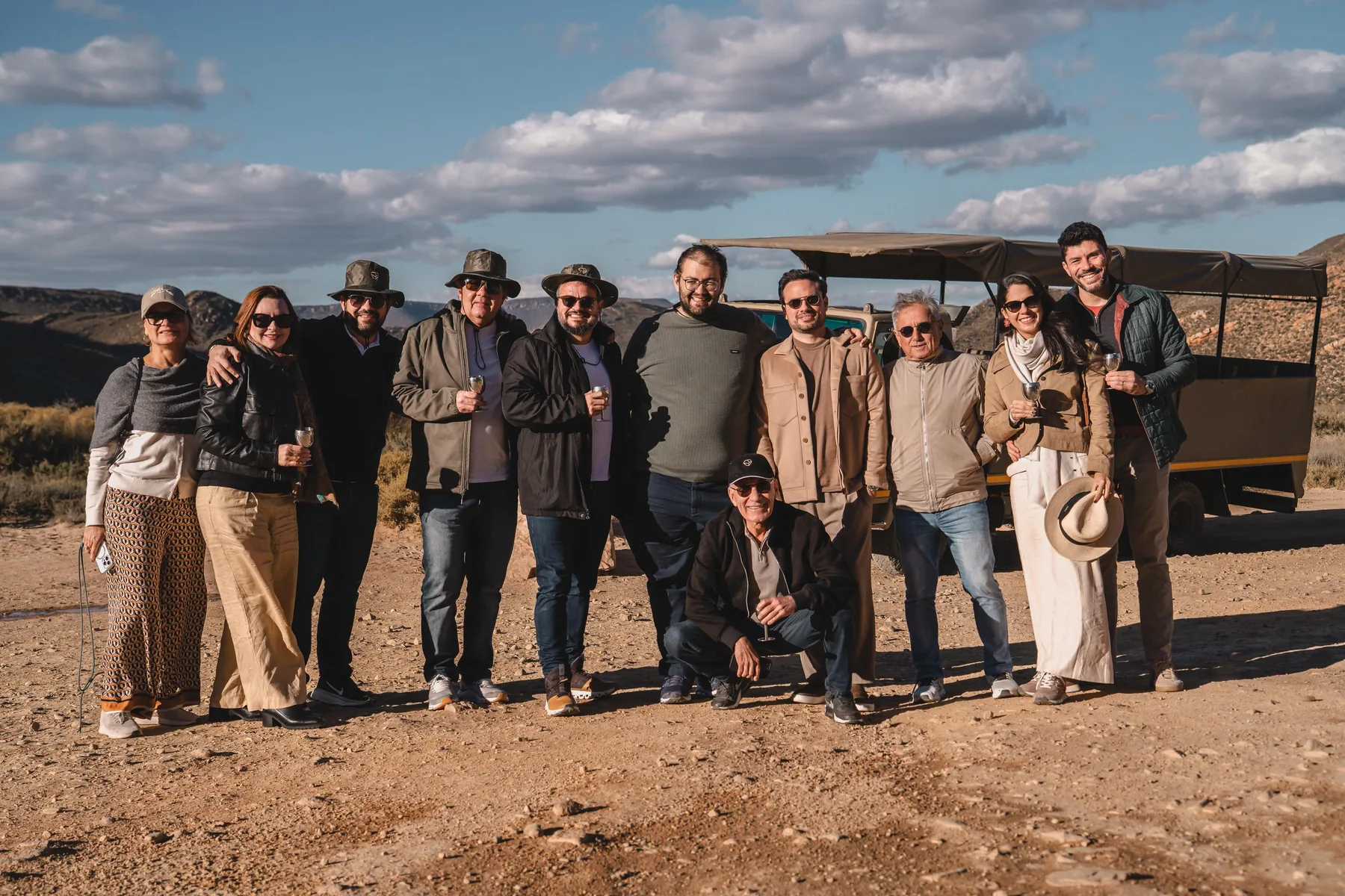O grupo reunido junto ao veículo, diante das montanhas.