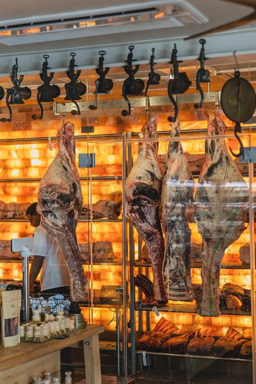 A charcutaria exposta liga criação, conservação e cozinha dentro do mesmo percurso.