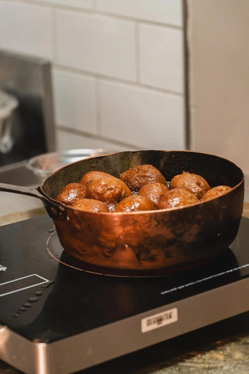 Preparos dourados fritam em uma panela de cobre